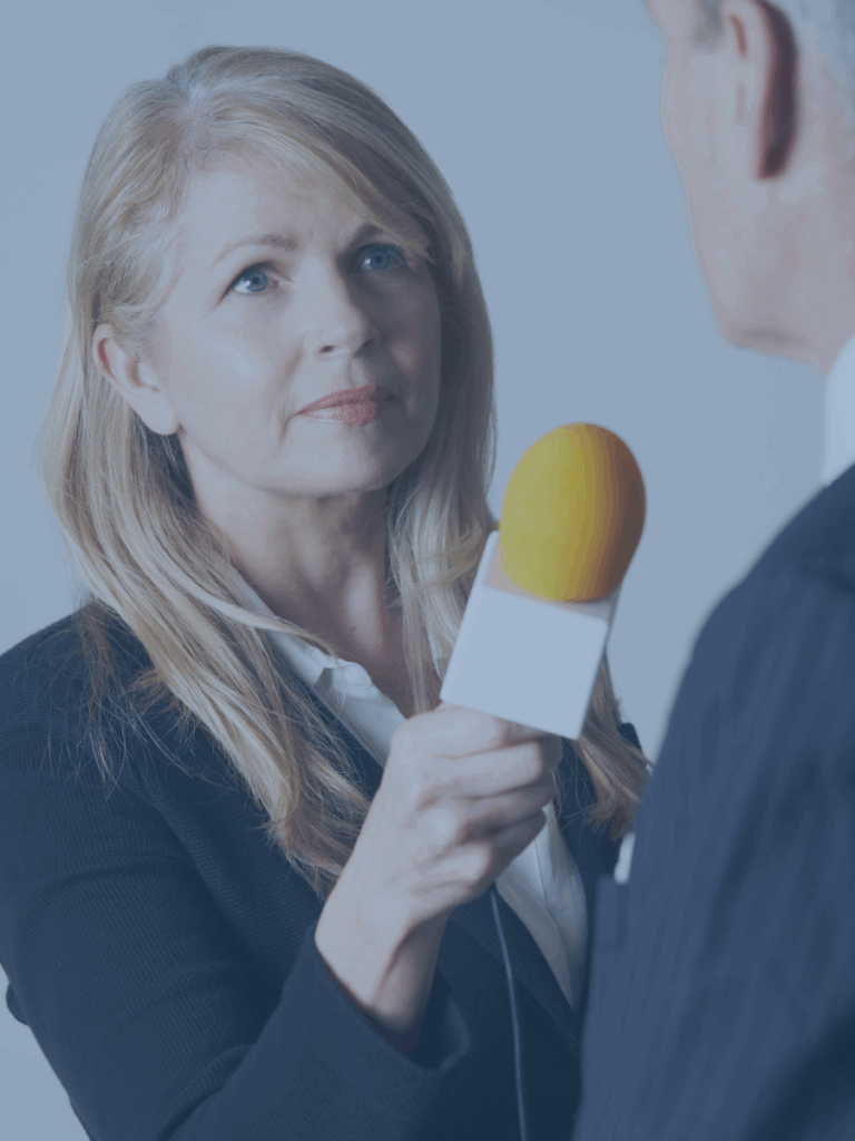Woman holding microphone interviewing someone.