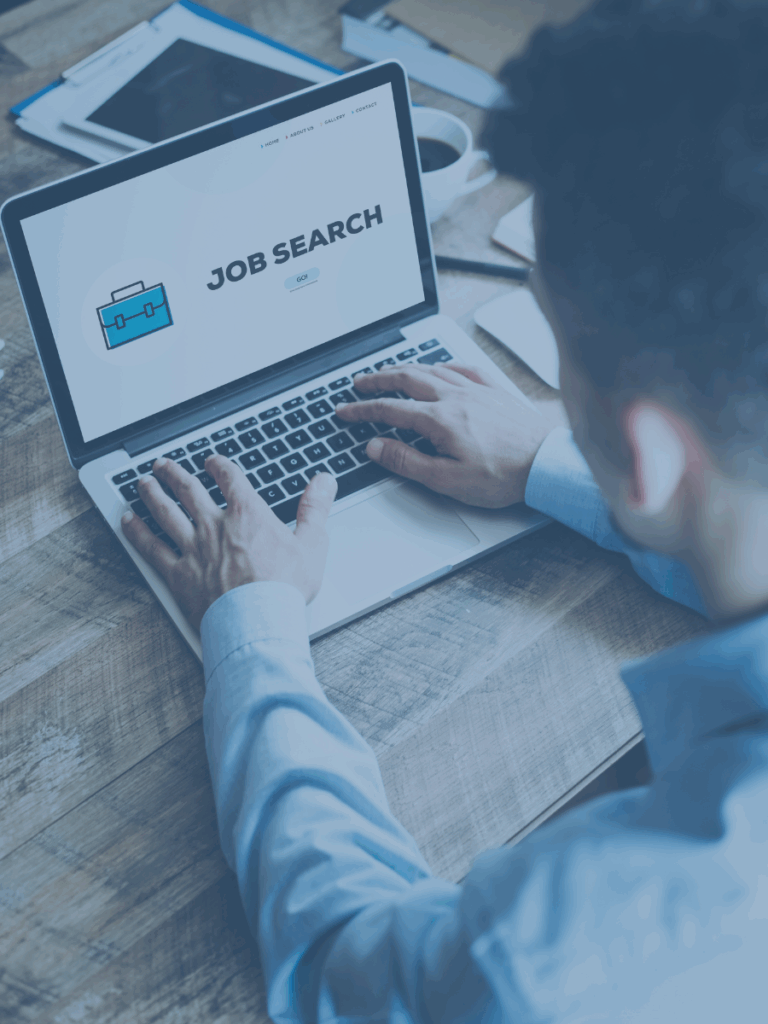 View from above and behind of a human searching a laptop for jobs.