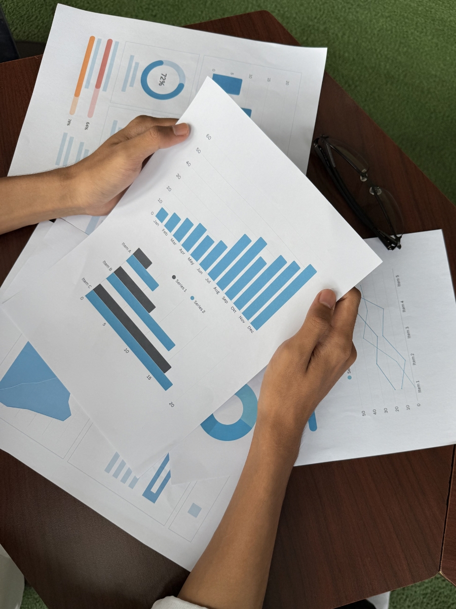 Person holding paper with graphs and charts